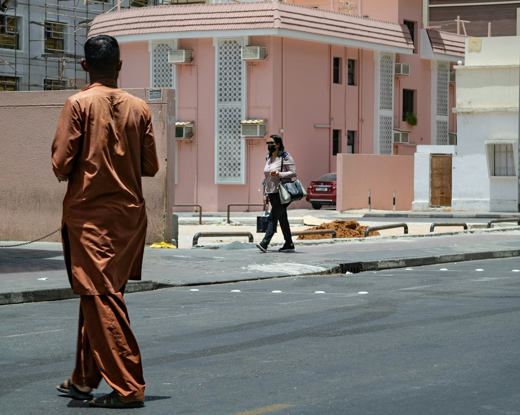 Two people walking along a street in Old Dubai
