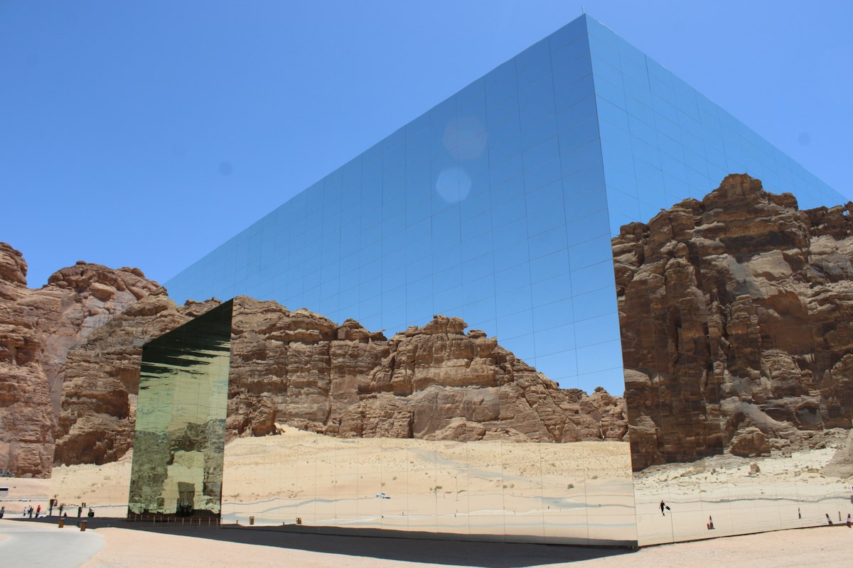 The mirrored Maraya building reflecting the sandstone cliffs of AlUla